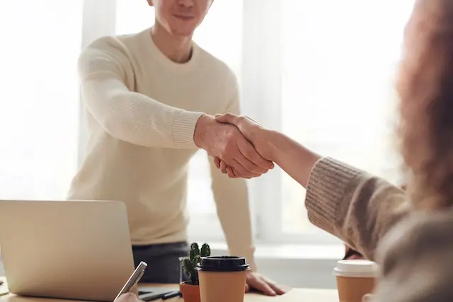 Image of a man shaking hands with a woman in an interview